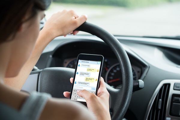 Woman who is texting and driving and may cause a distracted driving accident