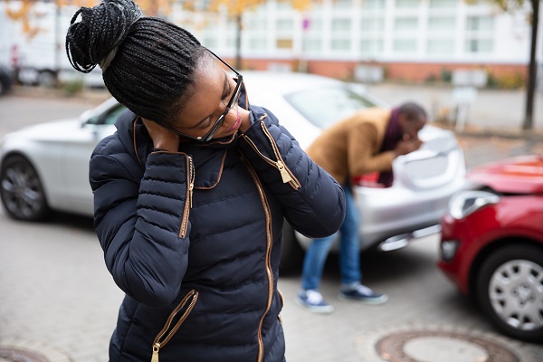 A woman who was just in a car crash holds her neck in pain