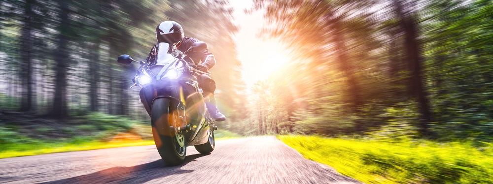 Man riding a motorcycle down a country highway