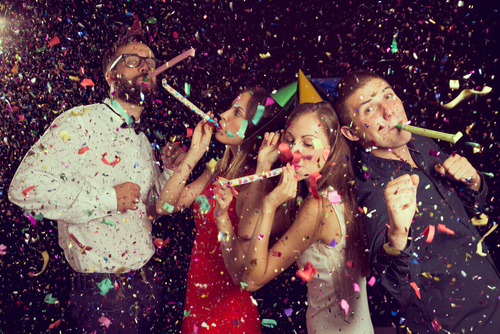couples having fun at New Years party wearing party hats and dancing couples having fun at New Years party wearing party hats and dancing