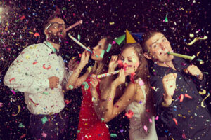 couples having fun at New Years party wearing party hats and dancing